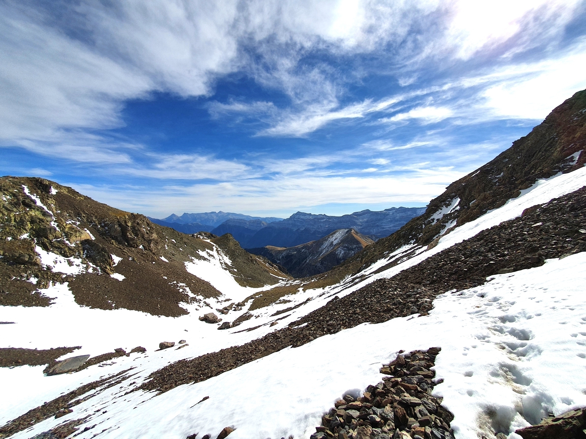 Steile Schotterpiste mit Schneefeldern an der Südflanke des Pico del Chinipro